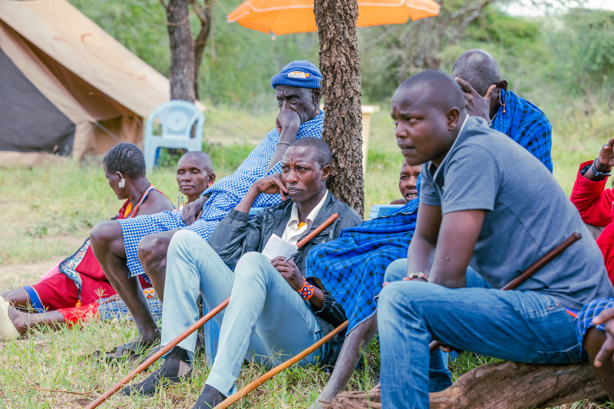 A man listening at a Maasai village meeting