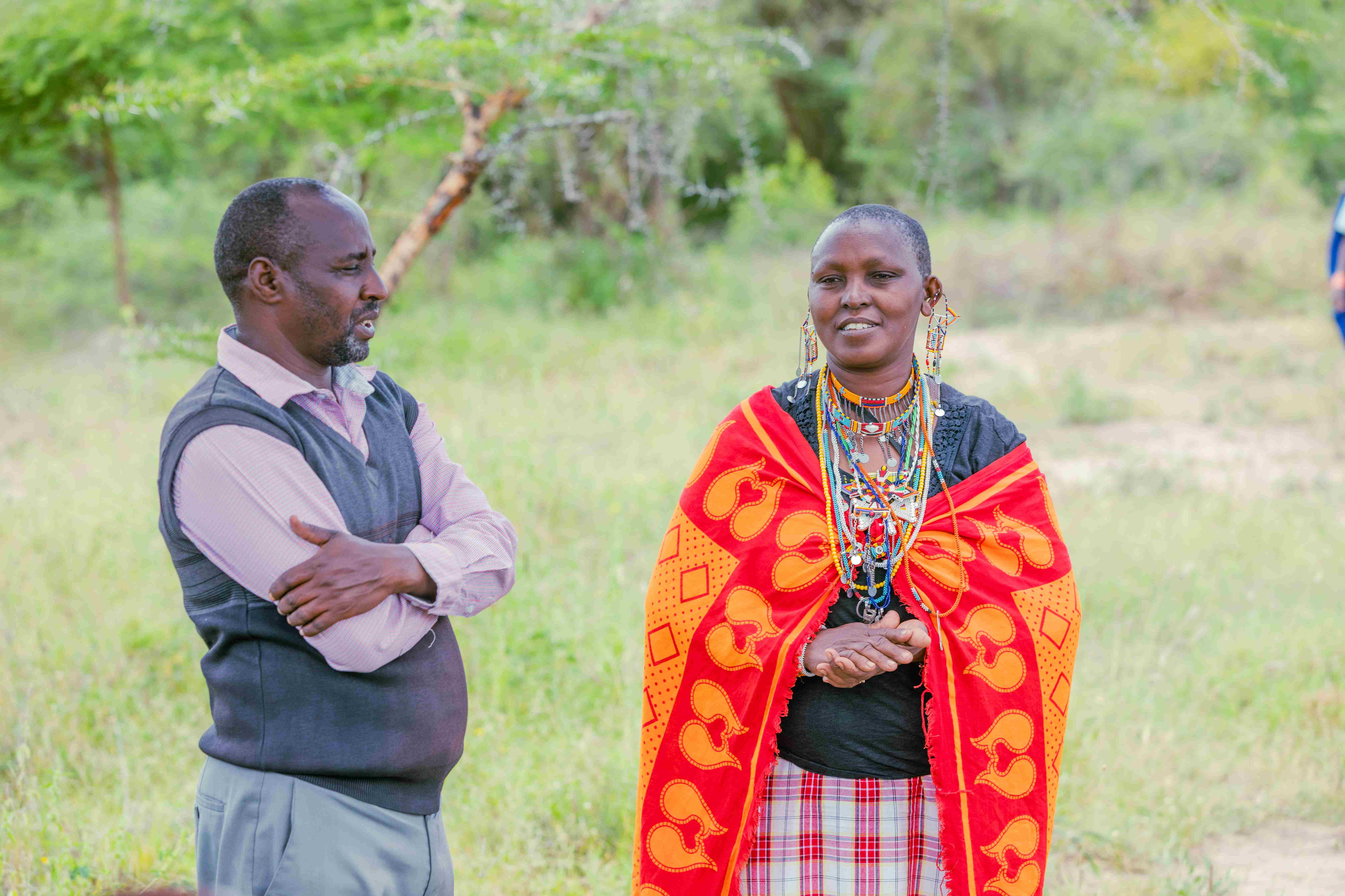 Maasai woman talking with a man on a grassland.